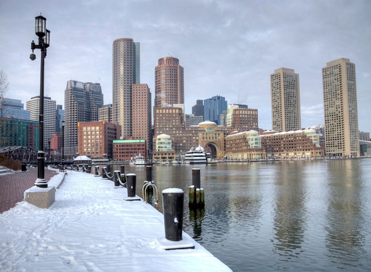 Walkway near water with skyscrapers in background