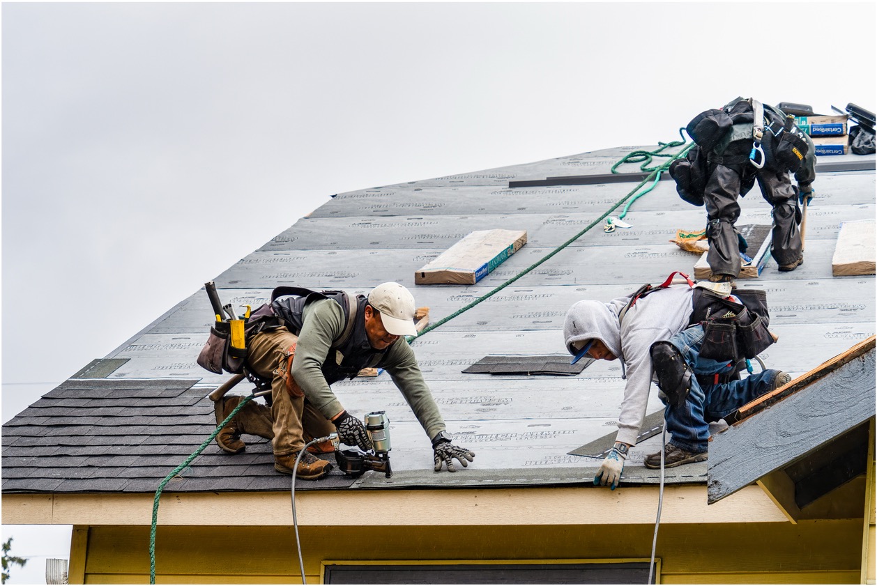 Image of men working on the roof of a house