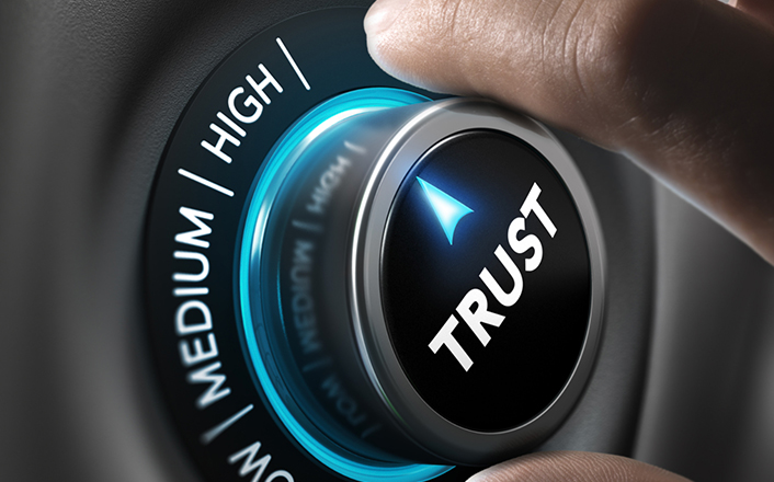 Hand turns dial labeled trust to high setting