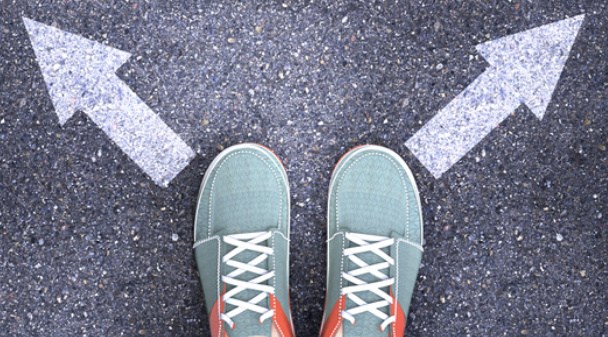 Person looks down at feet in front of two arrows