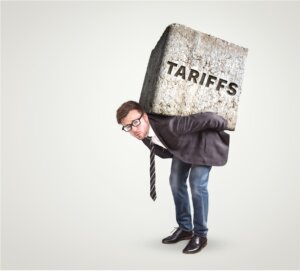 Man with heavy block on his back that reads "tariffs"