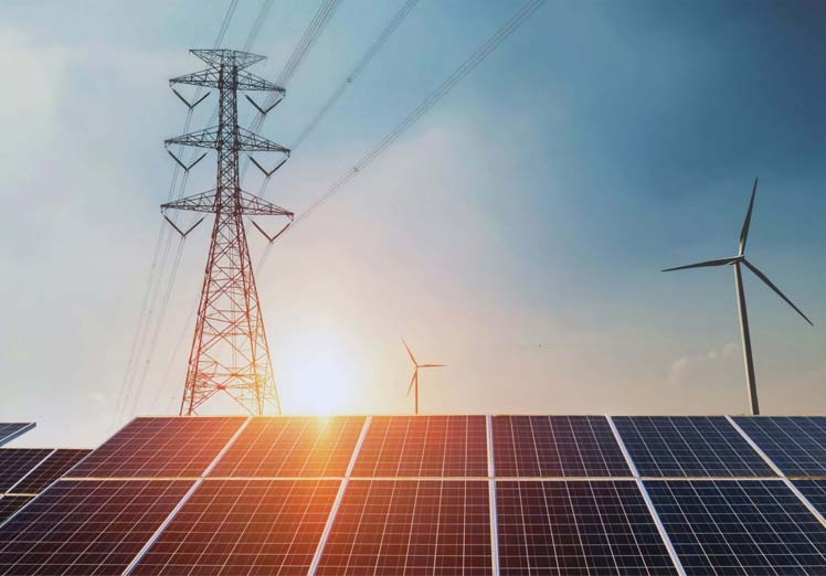 Solar panel with Electrical transformers and windmills in the background at sunset