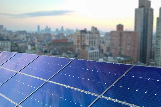 Close up of solar panel and city skyline in distance