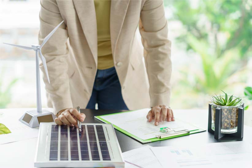 Man leaning over desk looking at clipboard
