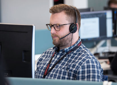 Man at a computer with headset on