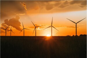 six windmills with sunset in the background