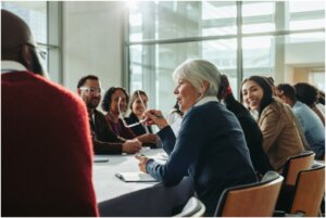 People in meeting and women in glasses talking