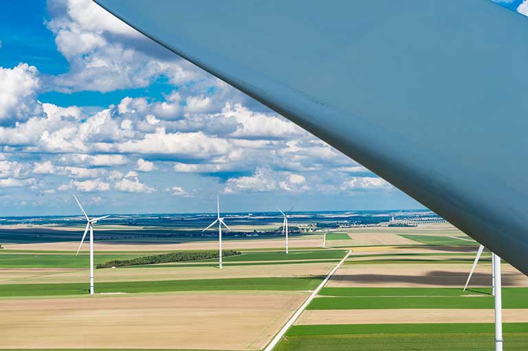 Close up of turbine blade and wind farm
