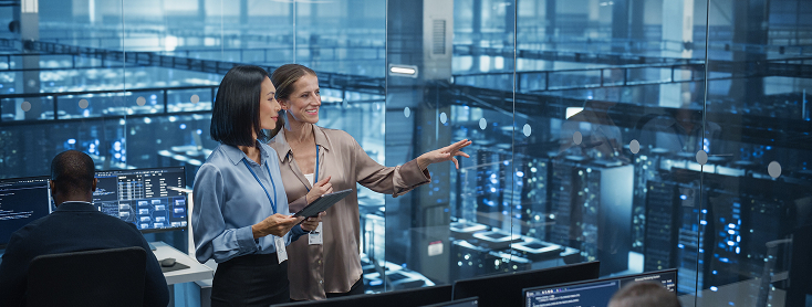 Two women talk in a data center